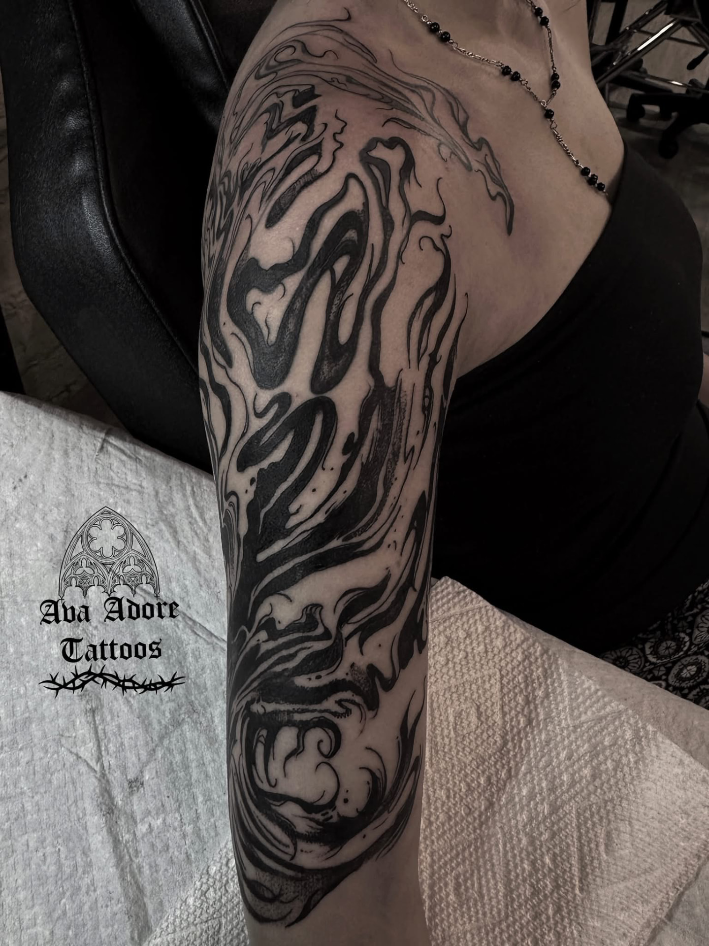Abstract liquid blackwork sleeve with flowing bold black shapes